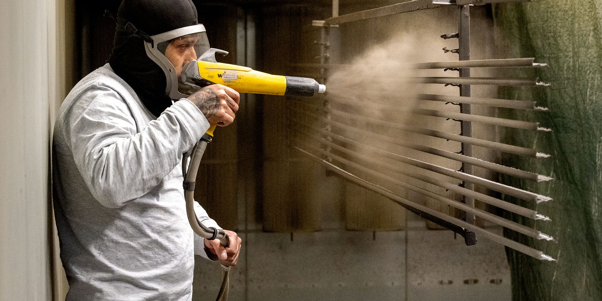 worker applying powder coating to divider strips